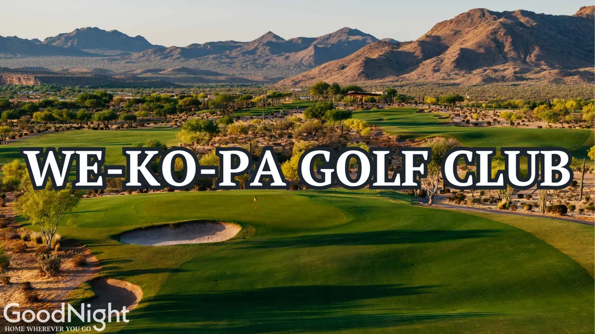 A pristine golf course stretches toward distant mountains, surrounded by lush greenery and set against a clear blue sky. The setting is peaceful and ideal for players seeking both challenge and natural beauty.